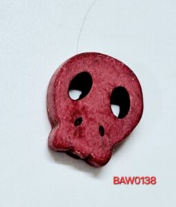 Manik tengkorak gepeng warna merah